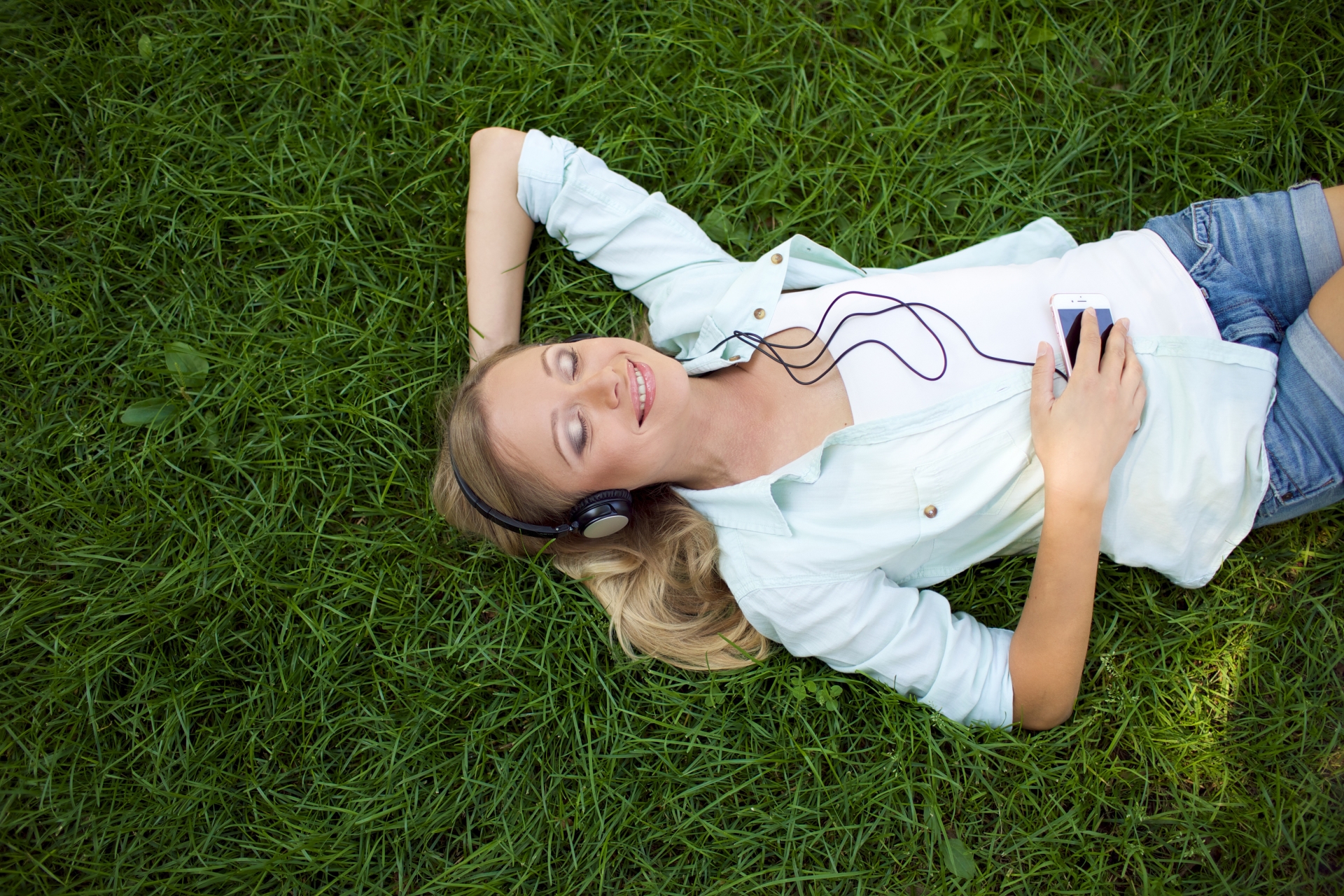 芝生で寝転びリラックスしているアラフォー女性