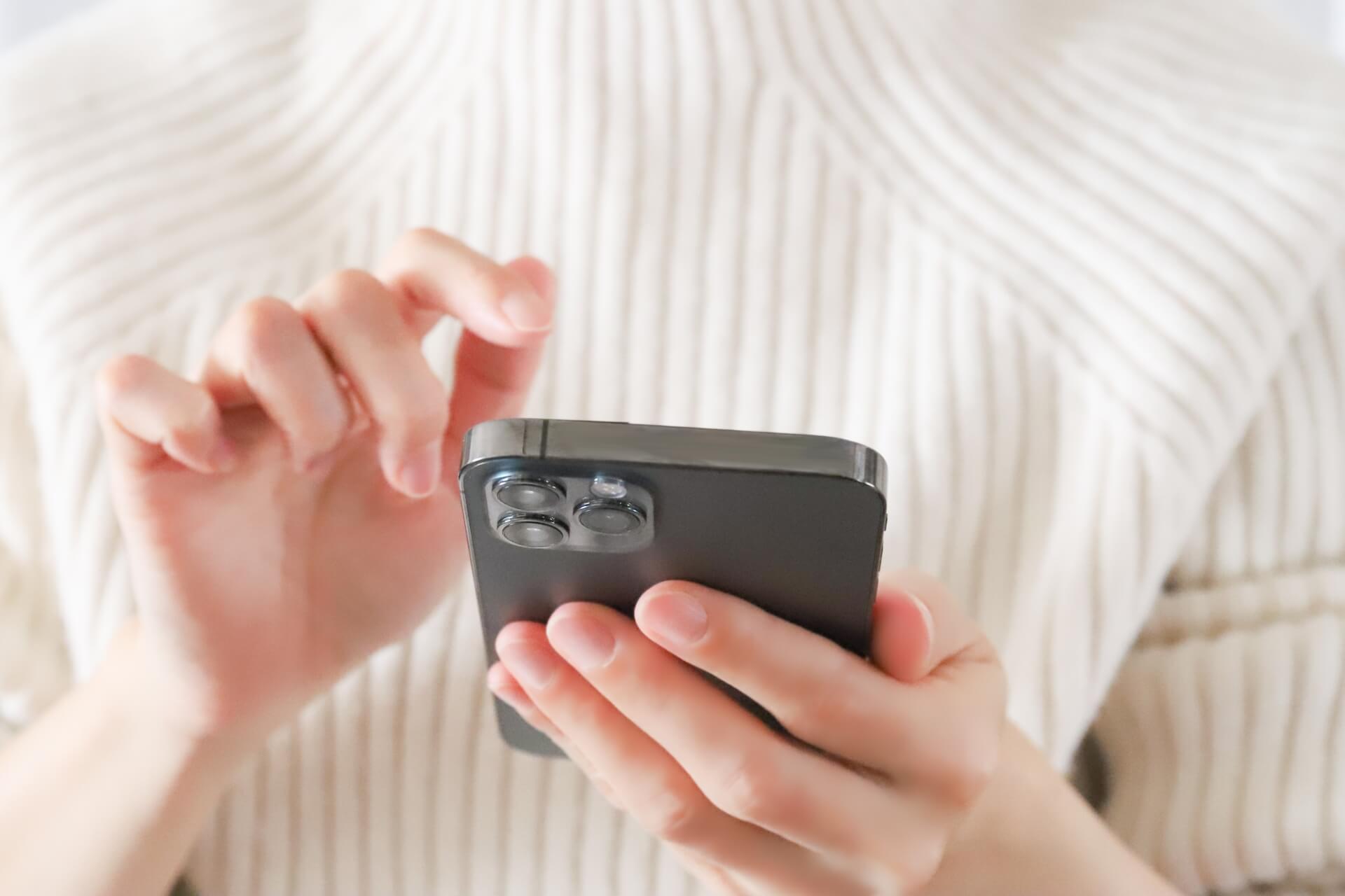 スマホで情報を調べる40代女性の手元
