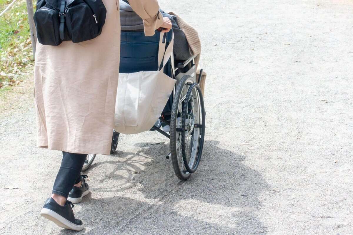 車椅子を押す女性の後ろ姿